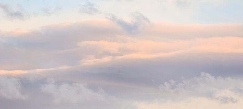 Background of blue sky with white and pink clouds in sunset. High quality photo