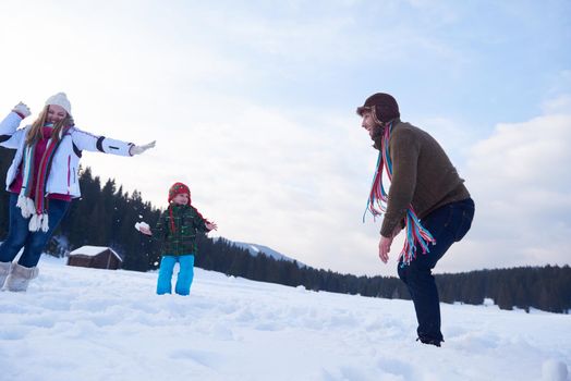 happy young  family playing in fresh snow  at beautiful sunny winter day outdoor in nature