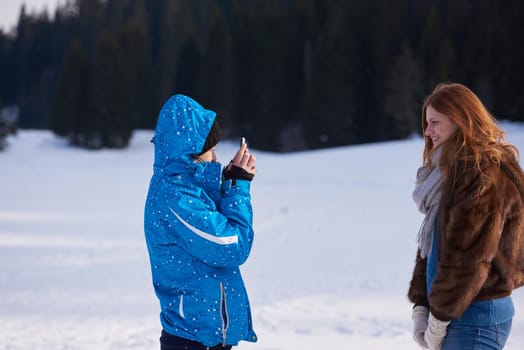 happy young  couple having fun and walking in snow shoes. Romantic winter relaxation scene