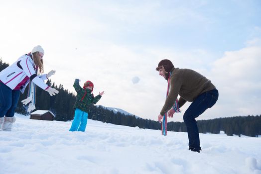 happy young  family playing in fresh snow  at beautiful sunny winter day outdoor in nature