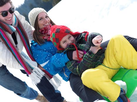 Winter playing, fun, snow and family portrait  sledding at winter time