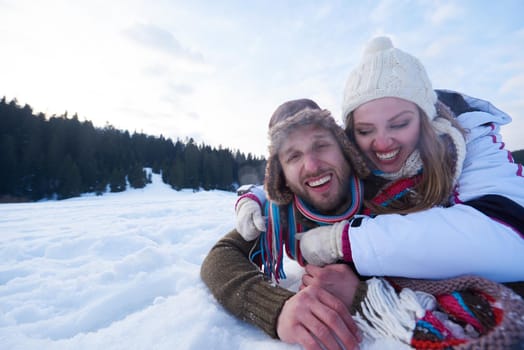 happy young  couple having fun and walking in snow shoes outdoor in nature at beautiful winter day. Health sport and relaxation