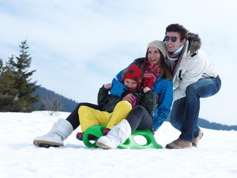 Winter playing, fun, snow and family portrait  sledding at winter time