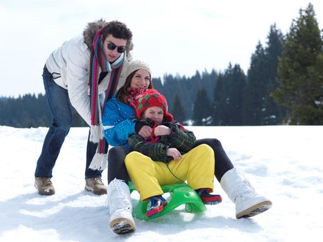 Winter playing, fun, snow and family portrait  sledding at winter time