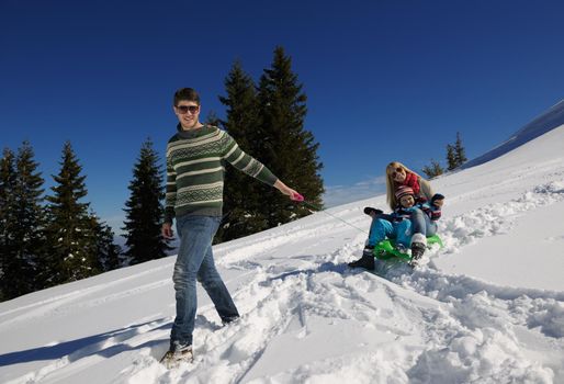 Winter season. Happy family having fun on fresh snow on vacation.