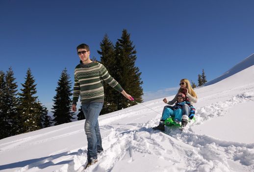 Winter season. Happy family having fun on fresh snow on vacation.