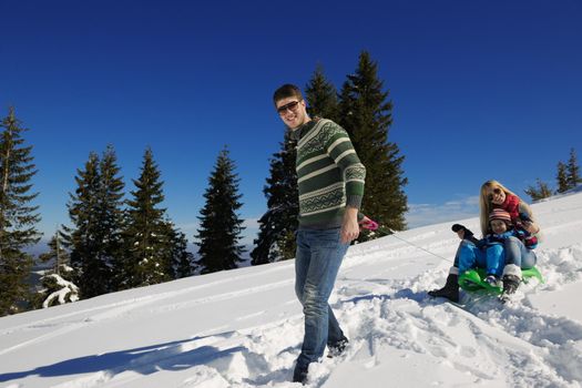 Winter season. Happy family having fun on fresh snow on vacation.