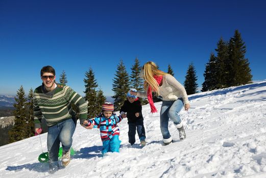 Winter season. Happy family having fun on fresh snow on vacation.