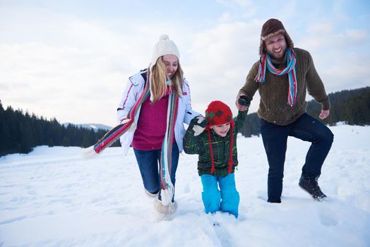 happy young  family playing in fresh snow  at beautiful sunny winter day outdoor in nature