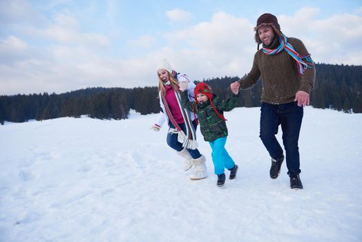 happy young  family playing in fresh snow  at beautiful sunny winter day outdoor in nature