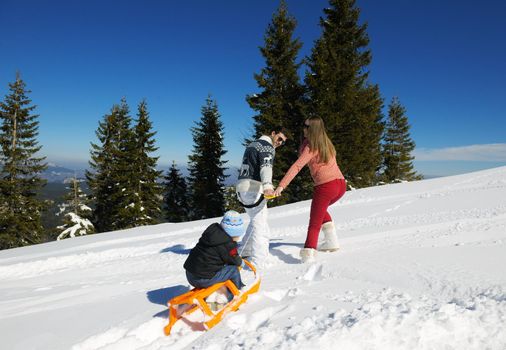 Winter season. Happy family having fun on fresh snow on vacation.