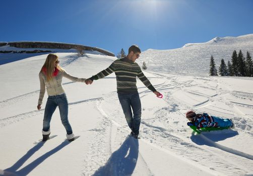 Winter season. Happy family having fun on fresh snow on vacation.