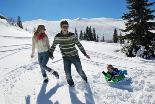 Winter season. Happy family having fun on fresh snow on vacation.