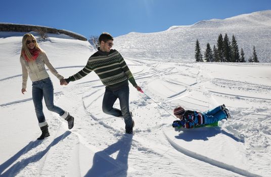 Winter season. Happy family having fun on fresh snow on vacation.