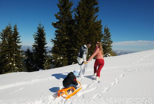 Winter season. Happy family having fun on fresh snow on vacation.