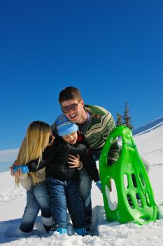 Winter season. Happy family having fun on fresh snow on vacation.