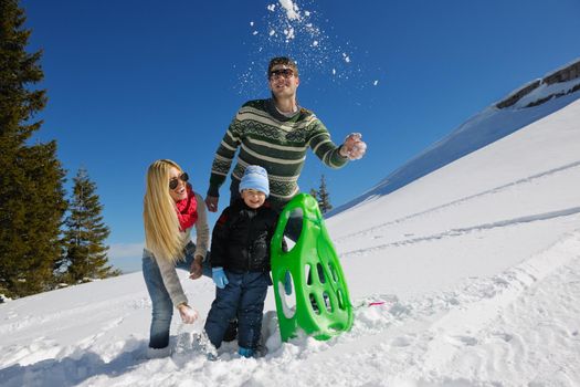 Winter season. Happy family having fun on fresh snow on vacation.