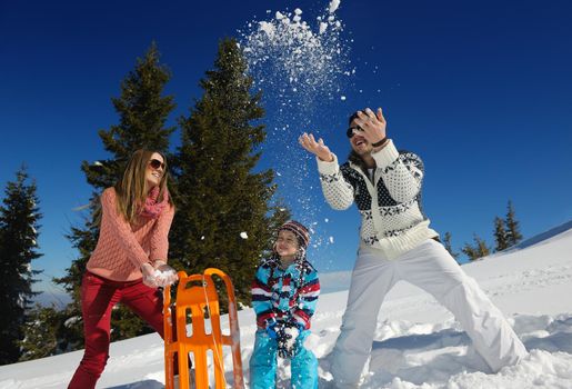 Winter season. Happy family having fun on fresh snow on vacation.