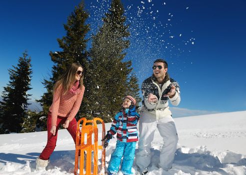 Winter season. Happy family having fun on fresh snow on vacation.