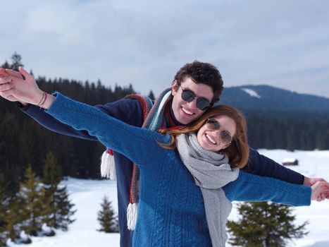 romantic winter  scene, happy young couple having fun on fresh show on winter vacatio, mountain nature landscape