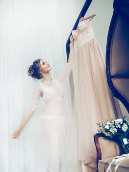 happy girl choosing wedding dress in wedding salon . photo with copy space
