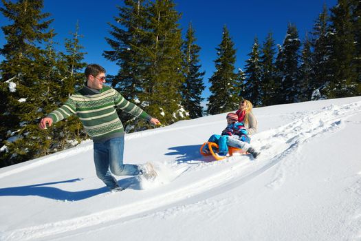 Winter season. Happy family having fun on fresh snow on vacation.