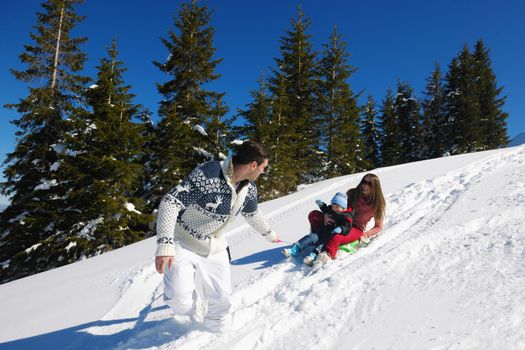 Winter season. Happy family having fun on fresh snow on vacation.