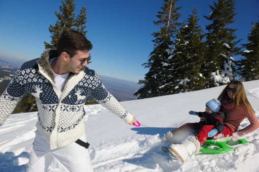 Winter season. Happy family having fun on fresh snow on vacation.