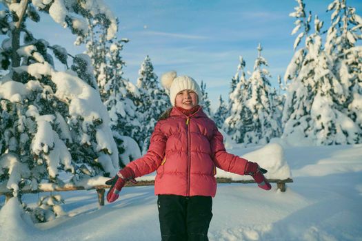 little girl having fun  throwing fresh snow at beautiful sunny winter day