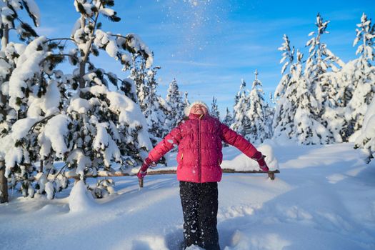 little girl having fun  throwing fresh snow at beautiful sunny winter day