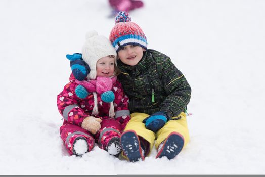 group of kids having fun and play together in fresh snow on winter vacation