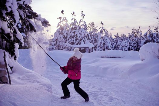 little girl having fun  throwing fresh snow at beautiful sunny winter day