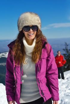 Happy young couple has fun on fresh snow at beautiful winter sunny day on vacation