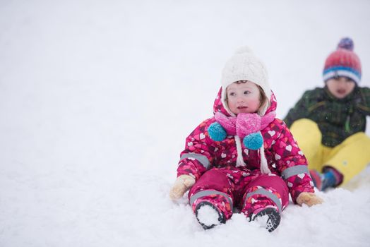 group of children having fun and play together in fresh snow on winter vacation