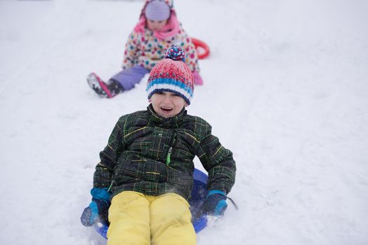 group of children having fun and play together in fresh snow on winter vacation