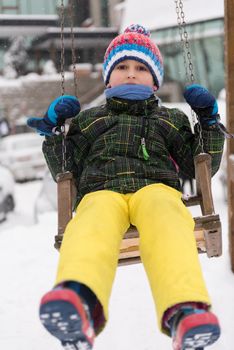 portrait of happy smiling little boy child outdoors having fun and playing on snowy winter day