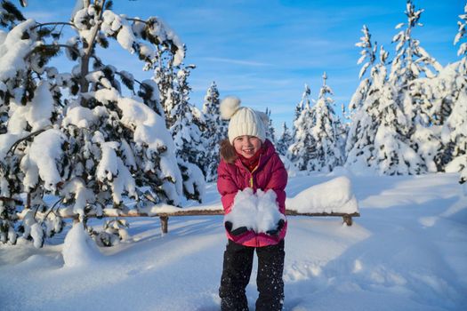 little girl having fun  throwing fresh snow at beautiful sunny winter day