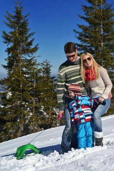 Winter season. Happy family having fun on fresh snow on vacation.