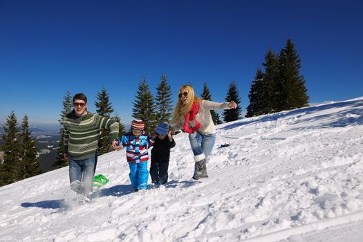 Winter season. Happy family having fun on fresh snow on vacation.