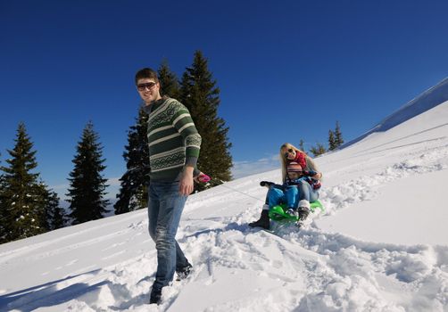 Winter season. Happy family having fun on fresh snow on vacation.