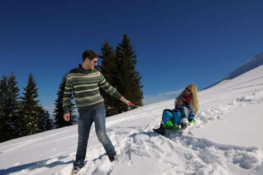 Winter season. Happy family having fun on fresh snow on vacation.