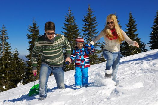 Winter season. Happy family having fun on fresh snow on vacation.