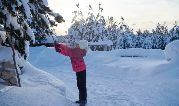 little girl having fun  throwing fresh snow at beautiful sunny winter day