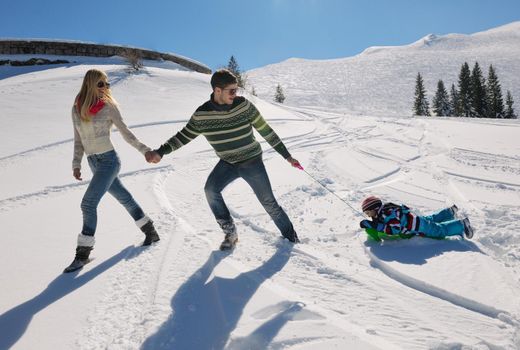 Winter season. Happy family having fun on fresh snow on vacation.