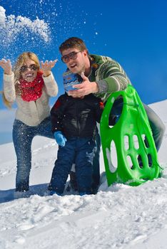 Winter season. Happy family having fun on fresh snow on vacation.