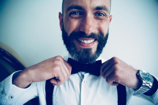 close up. happy man adjusting his bow tie. people and events