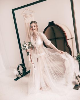 happy bride in boudoir dresses hotel room. Morning of the bride.