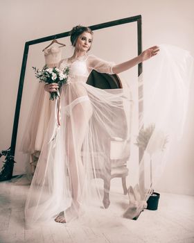 happy bride in a transparent Cape is preparing for the wedding ceremony. Morning of the bride.