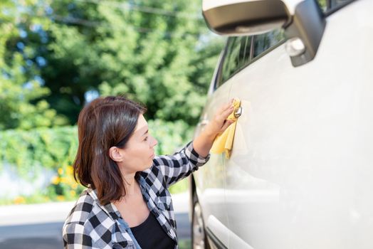 Woman using microfiber rag for car polishing