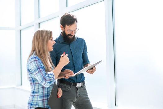 boss and assistant discussing work schedule is standing in the office corridor. office weekdays